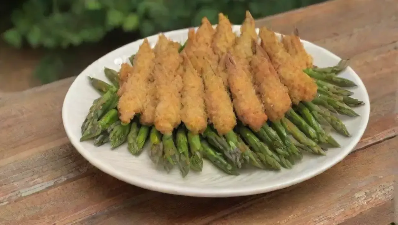 Espárragos verdes crujientes con tempura dorada, hierbas frescas y salsa, presentados elegantemente en un ambiente primaveral