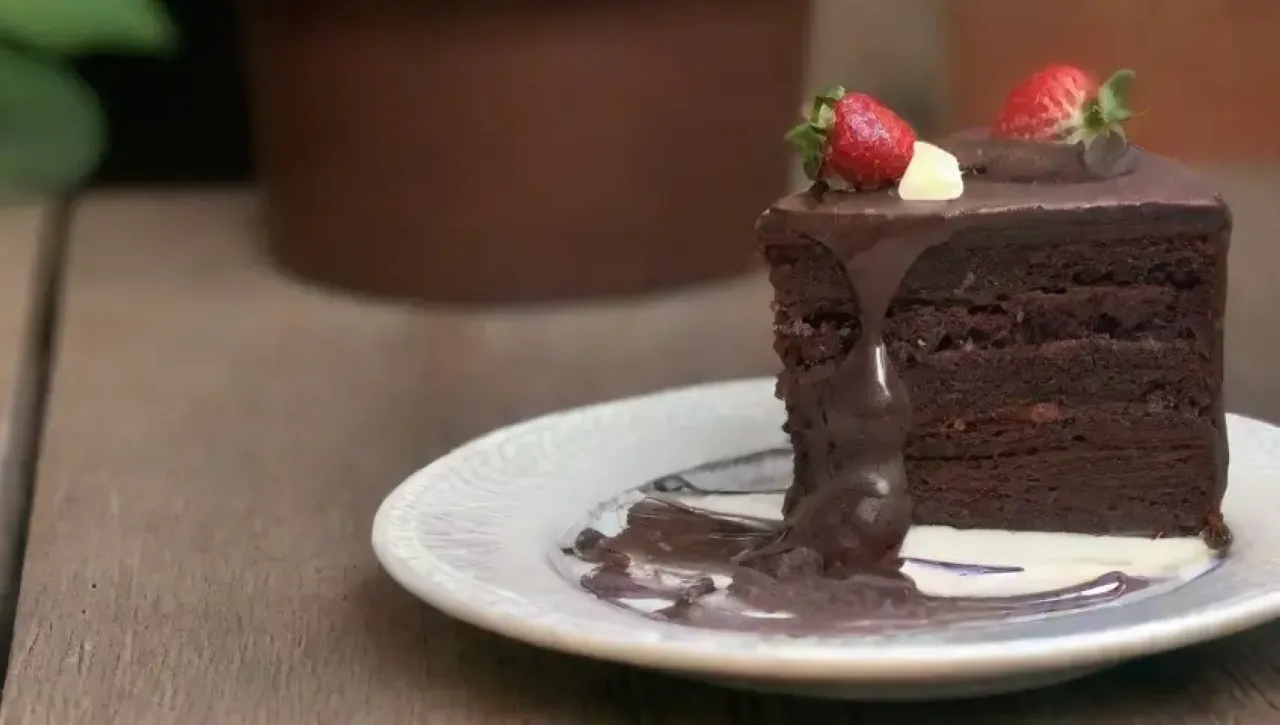 Un delicioso pastel de chocolate con fresas y un ambiente acogedor