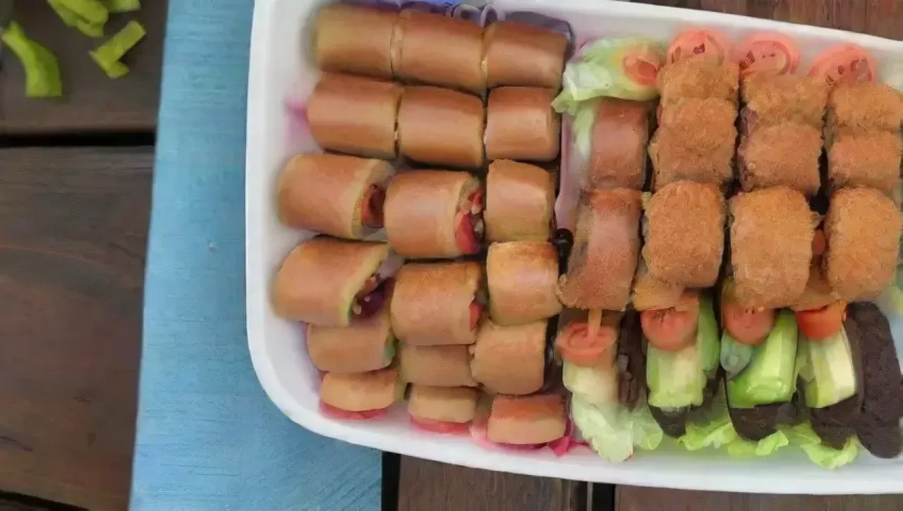 Mini hamburguesas coloridas con pollo, acompañadas de papas fritas y salsa, sobre una mesa rústica con luz suave