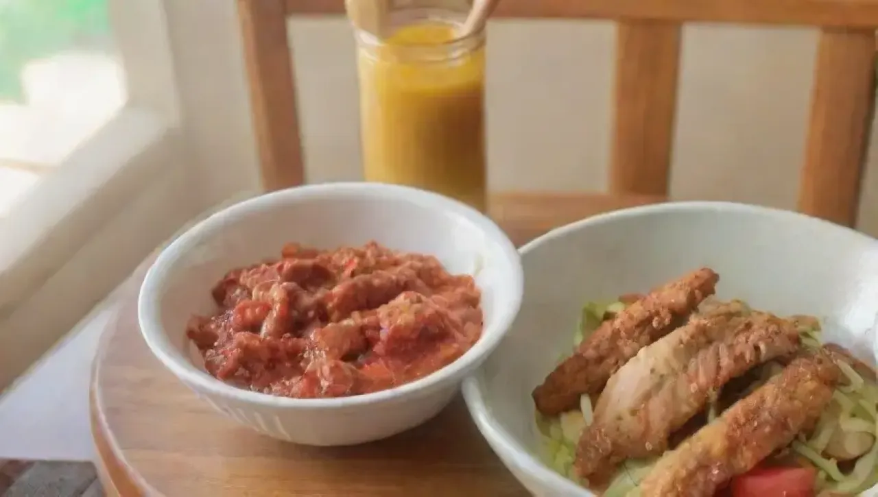 Una mesa acogedora y colorida lista para un festín con mostaza, miel, verduras y pollo crujiente