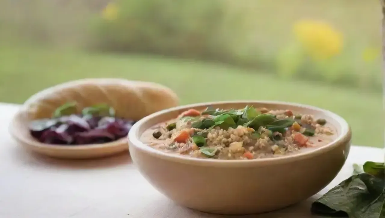 Sopa de quinoa vibrante con verduras coloridas en un ambiente acogedor