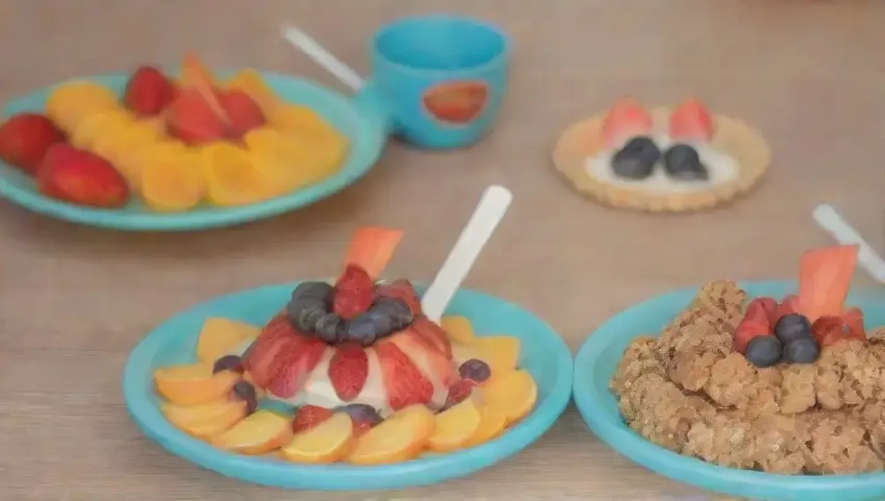 Un festín colorido y alegre de yogur, frutas y sonrisas en un ambiente soleado