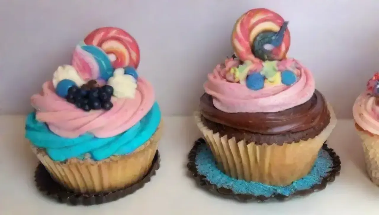 Una mesa de postres coloridos y artísticos con pasteles, cupcakes y decoraciones deliciosas