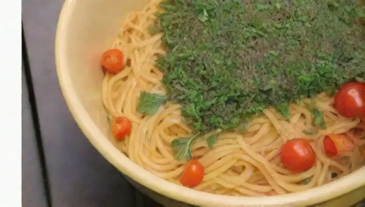 Una escena acogedora de cocina con pasta, verduras frescas y risas