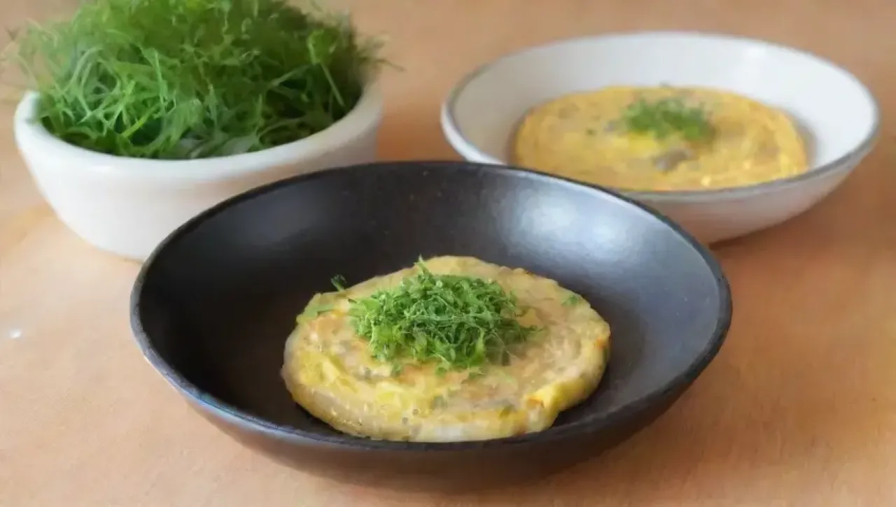 Un desayuno acogedor de omelet de calabacín amarillo con parmesano y hierbas, listo para disfrutar
