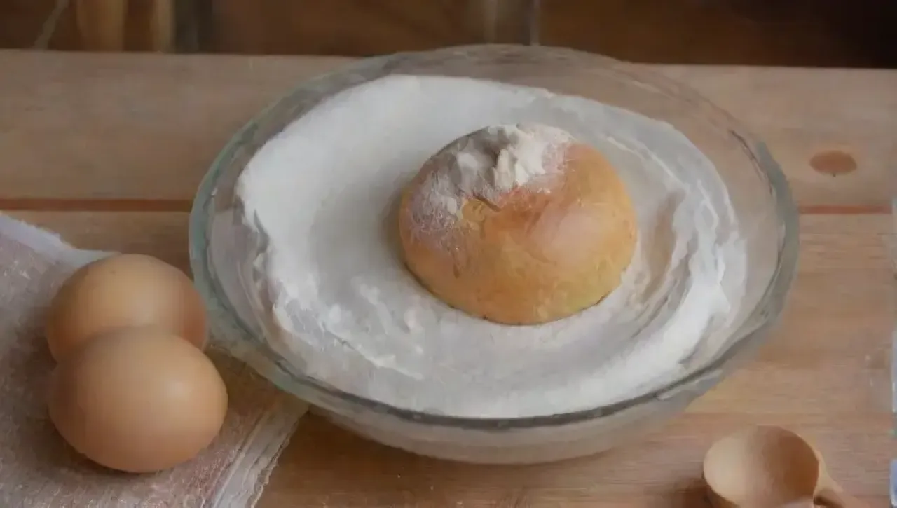Una alegre panadera sonríe en una cocina llena de colores suaves y utensilios de repostería