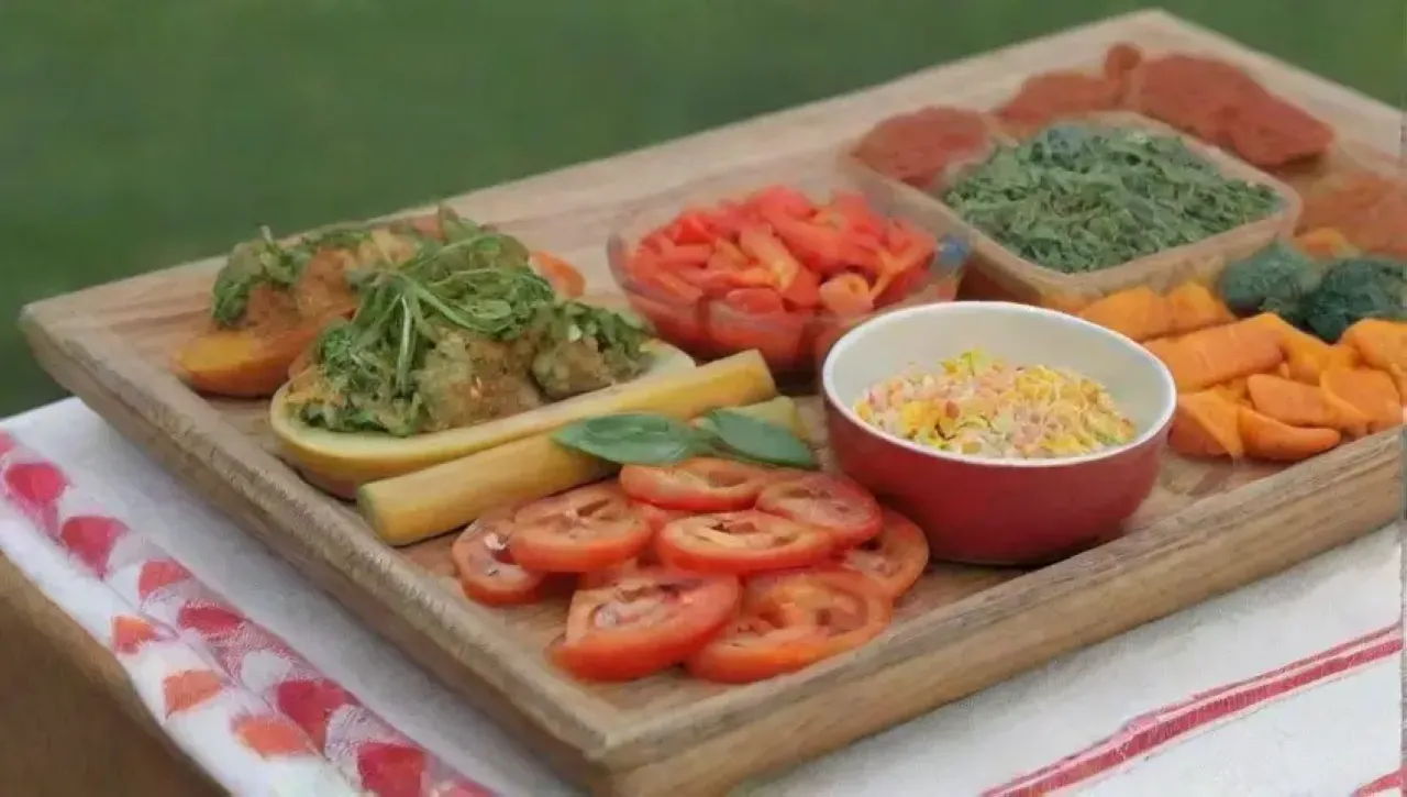 Una mesa colorida y acogedora con hierbas frescas, bocados crujientes, verduras, dips cremosos y un aroma tentador