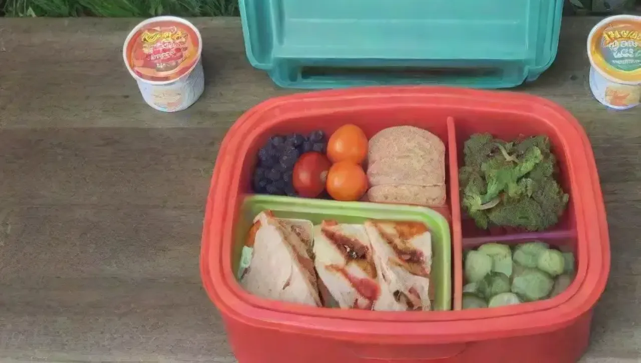 Una colorida lonchera con compartimentos ordenados y comida fresca y saludable