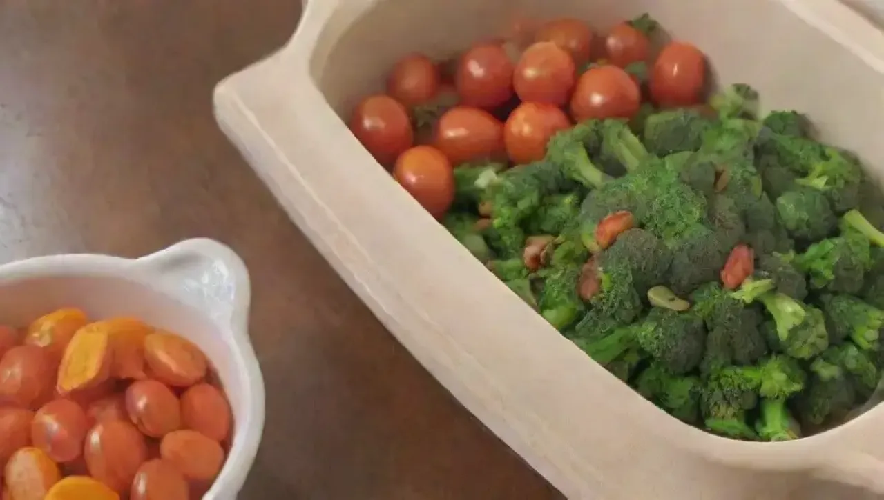 Una cocina acogedora llena de verduras frescas, utensilios y una familia disfrutando de una comida