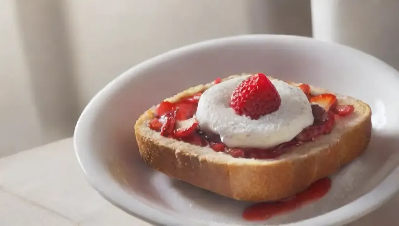 Un delicioso desayuno de tostadas doradas con fresas, jarabe de arce y un ambiente acogedor