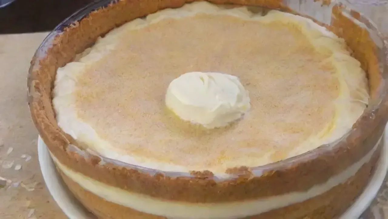 Preparando un cheesecake con una base crujiente y una mezcla suave, listo para servir