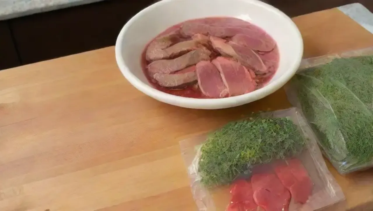 Una cocina elegante con ingredientes frescos y un ambiente acogedor, donde se disfruta de un exquisito steak sous-vide