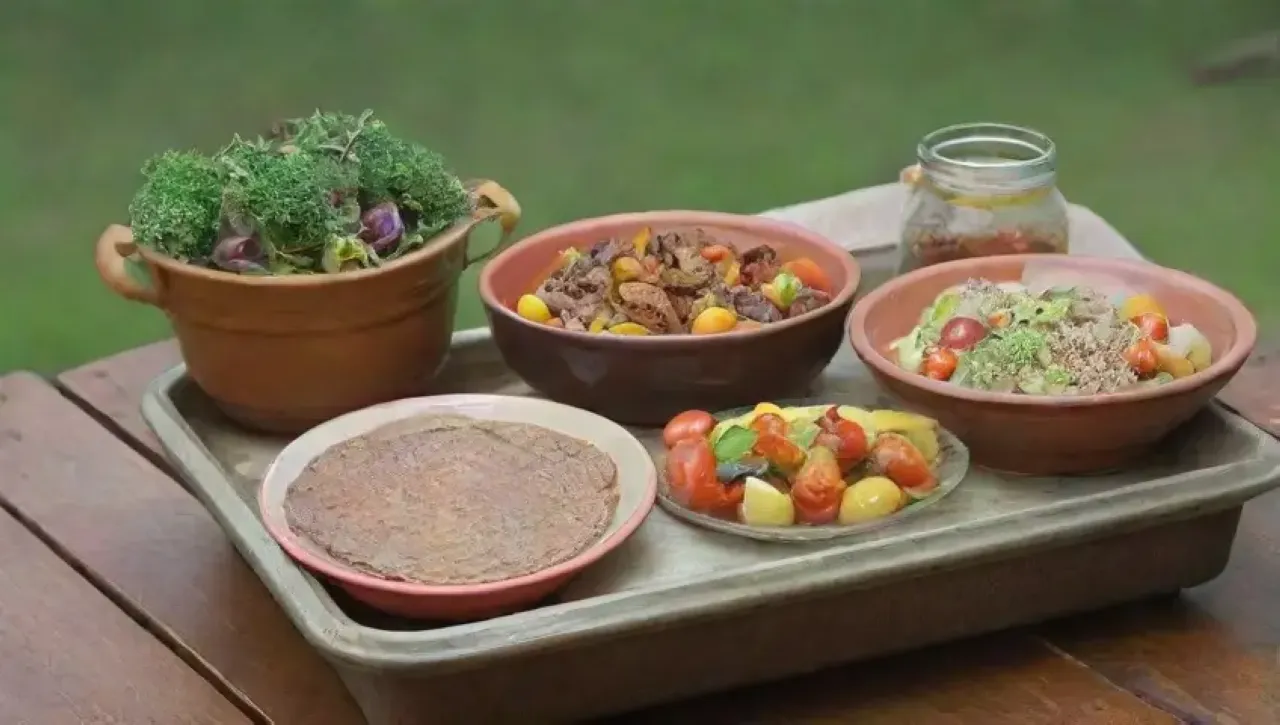 Una mesa vibrante y acogedora con platos coloridos, hierbas frescas, pollo a la parrilla y una ensalada variada