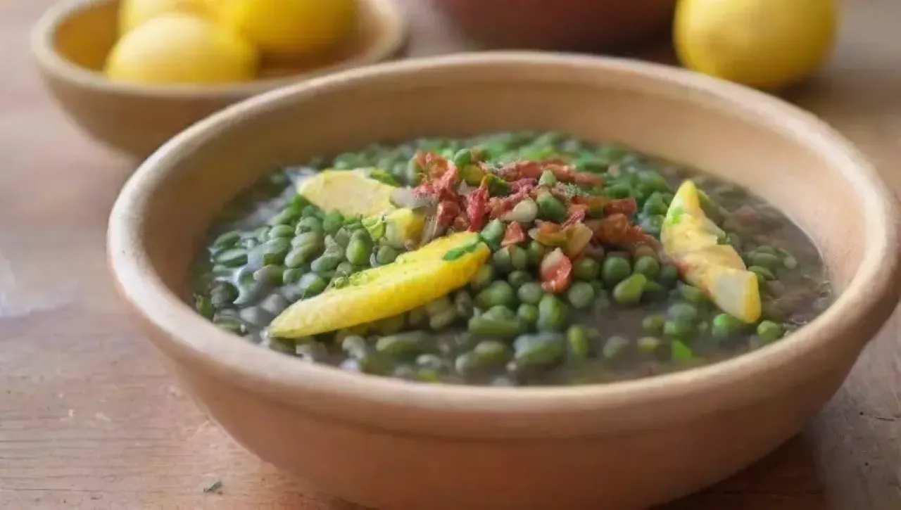 Un plato colorido de habas verdes con caldo, hierbas frescas, limón, pan y un ambiente acogedor