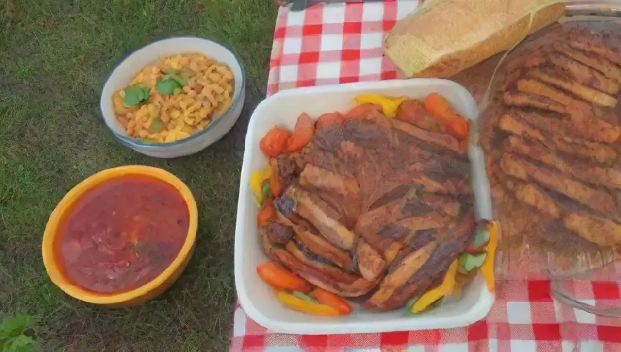 Una mesa rústica con comida deliciosa y una familia feliz disfrutando al aire libre