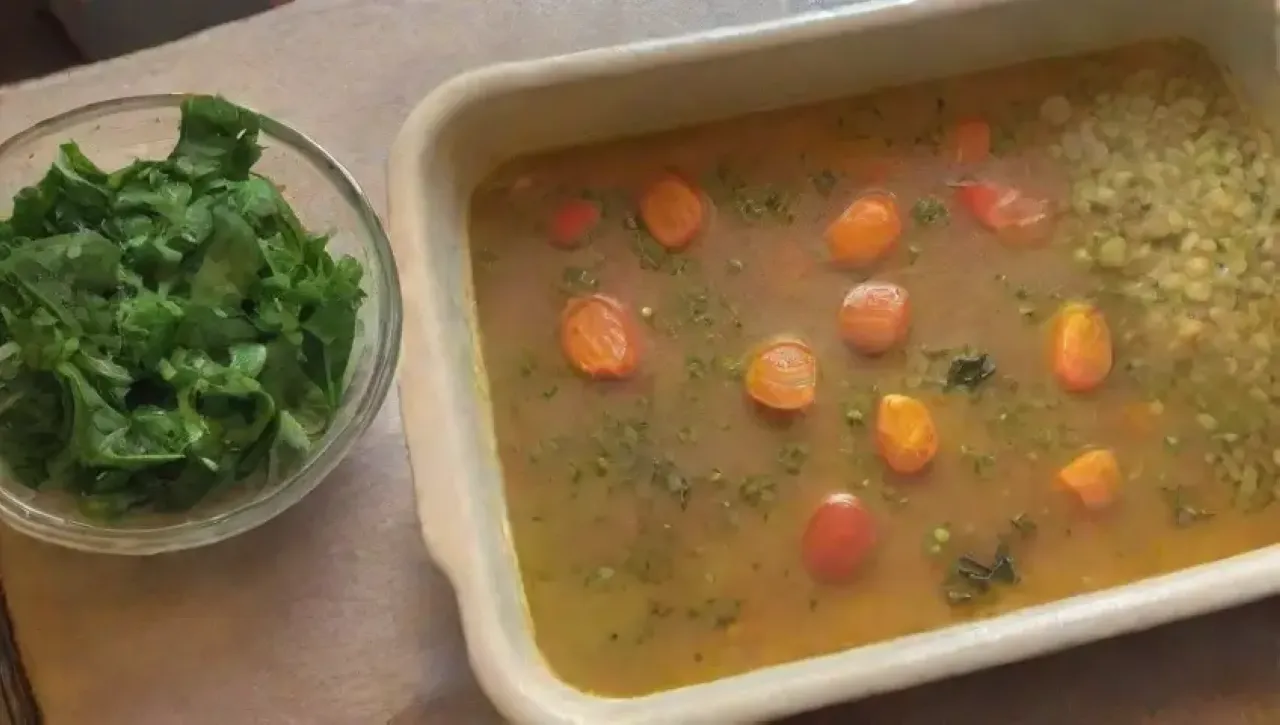 Una acogedora cocina humeante con guisantes verdes, cebollas amarillas, ajo, zanahorias, tomillo, caldo de verduras y un aroma reconfortante