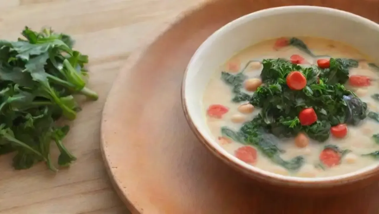 Sopa cremosa de frijoles blancos con kale, hierbas verdes, aceite de oliva, pan crujiente y un ambiente acogedor