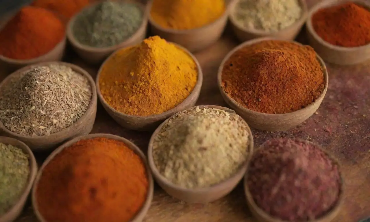 Especias y hierbas coloridas fusionan culturas en platos tradicionales con técnicas modernas y sabores diversos
