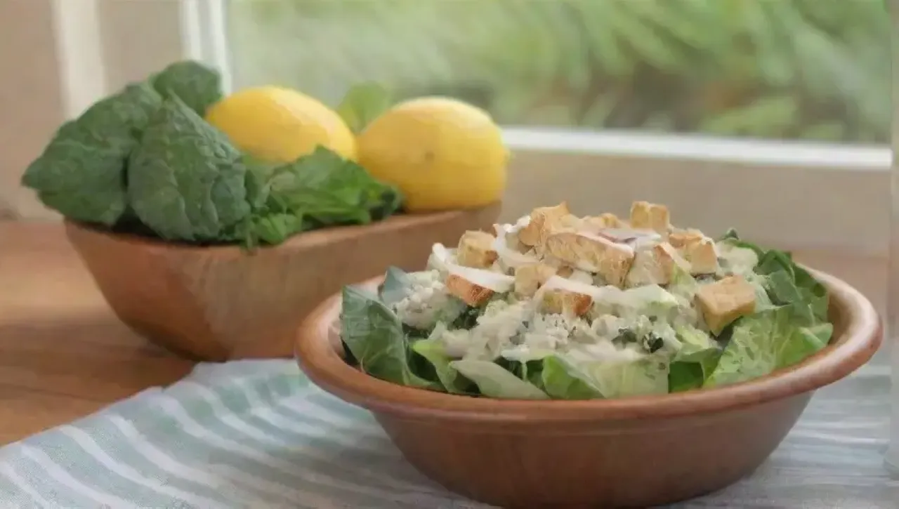 En un ambiente alegre, una ensalada César fresca y colorida invita a disfrutar de un estilo de vida saludable