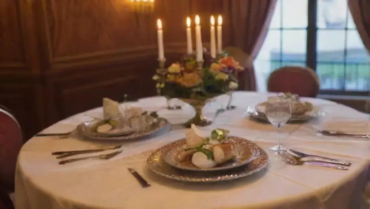 Un elegante restaurante con mesas decoradas, vajilla fina y un ambiente acogedor