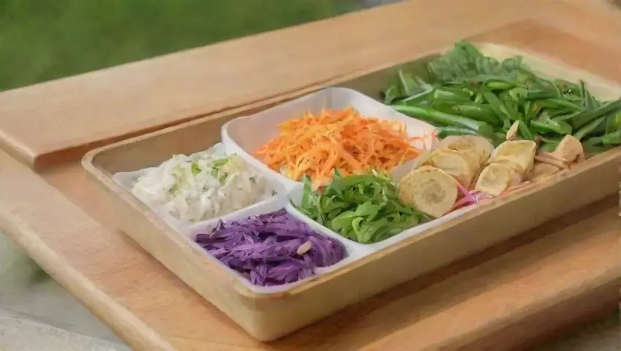 Una cocina alegre prepara coloridos rollos de primavera con frescos ingredientes