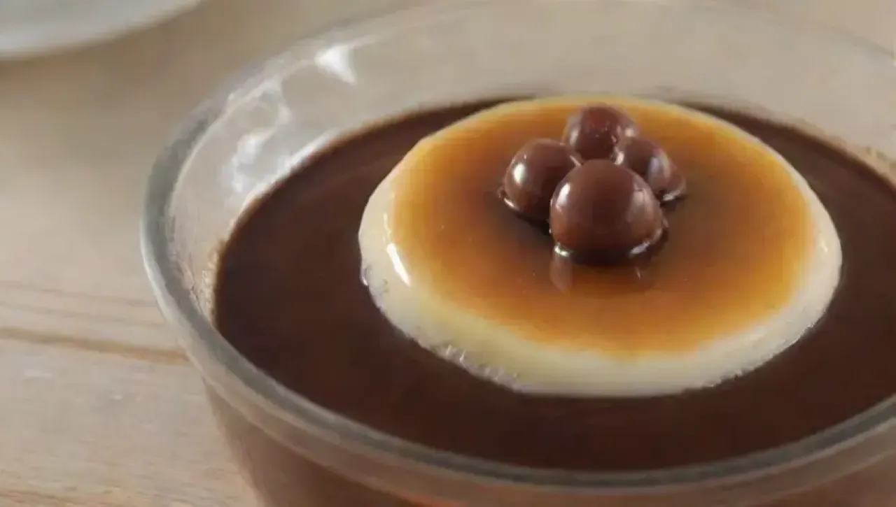 Un delicioso flan de chocolate con caramelo y fresas, listo para disfrutar