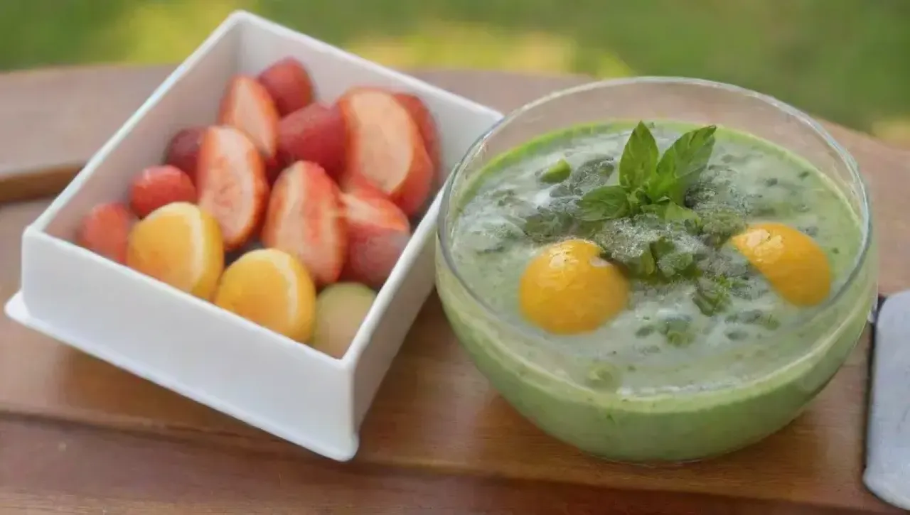 Un vibrante tazón de smoothie verde con frutas frescas y un ambiente saludable