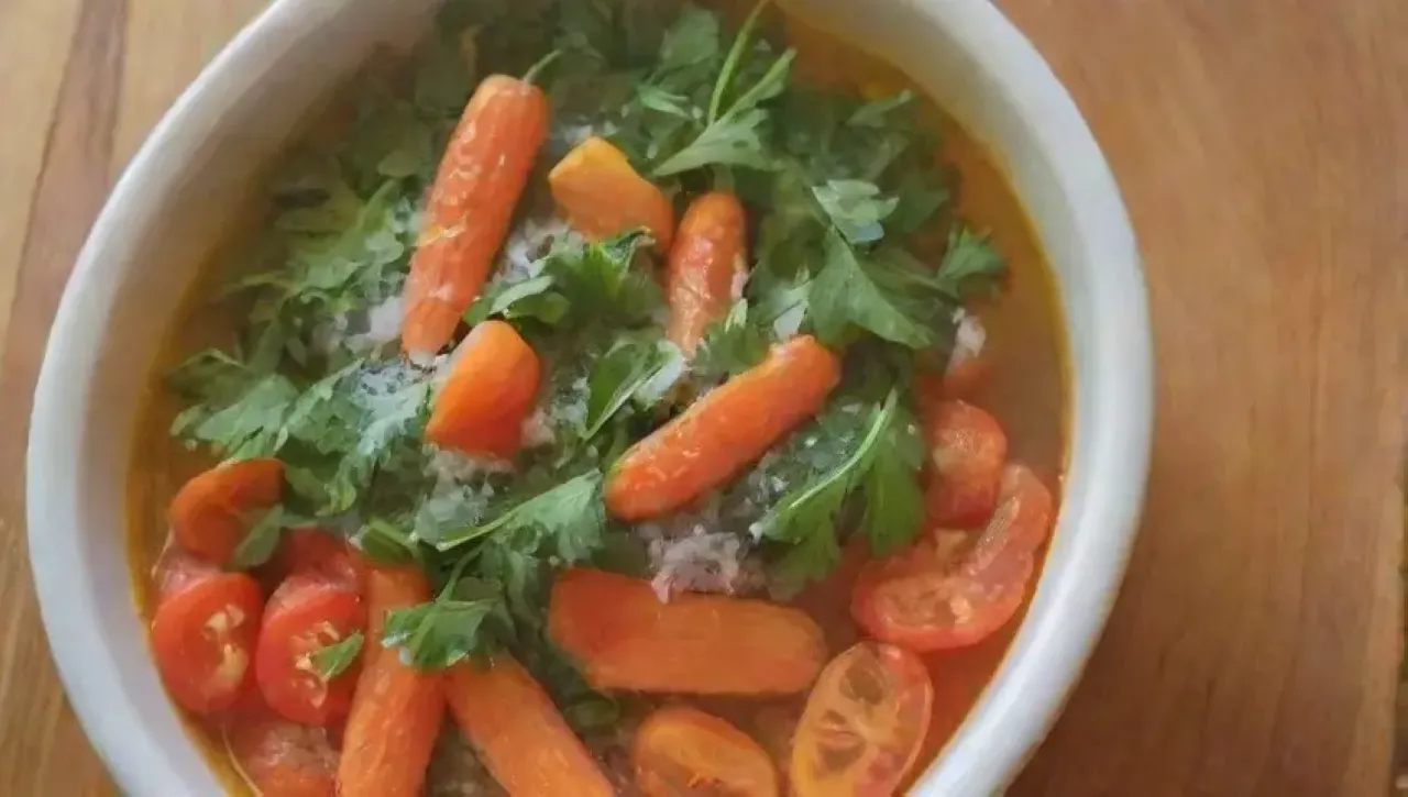 Una colorida y fresca ensalada con zanahorias, coco, cilantro, tomates y un toque de limón en un ambiente alegre