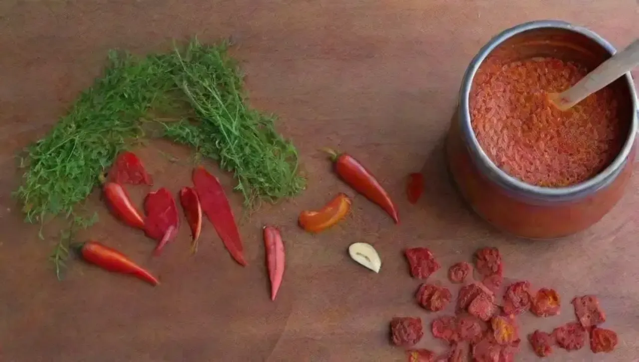Un acogedor ambiente de cocina con pimientos rojos, hierbas frescas y un libro de recetas