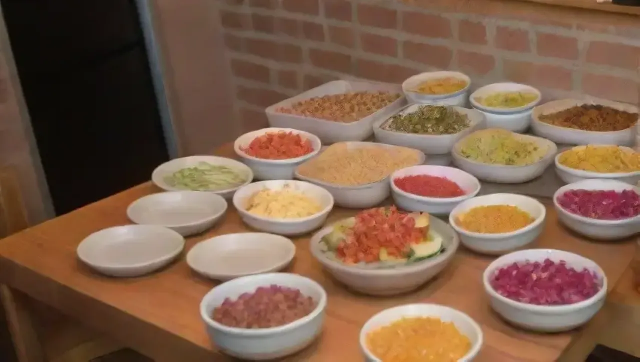 Escena culinaria vibrante con chefs, especias coloridas, platos fusionados y un ambiente acogedor