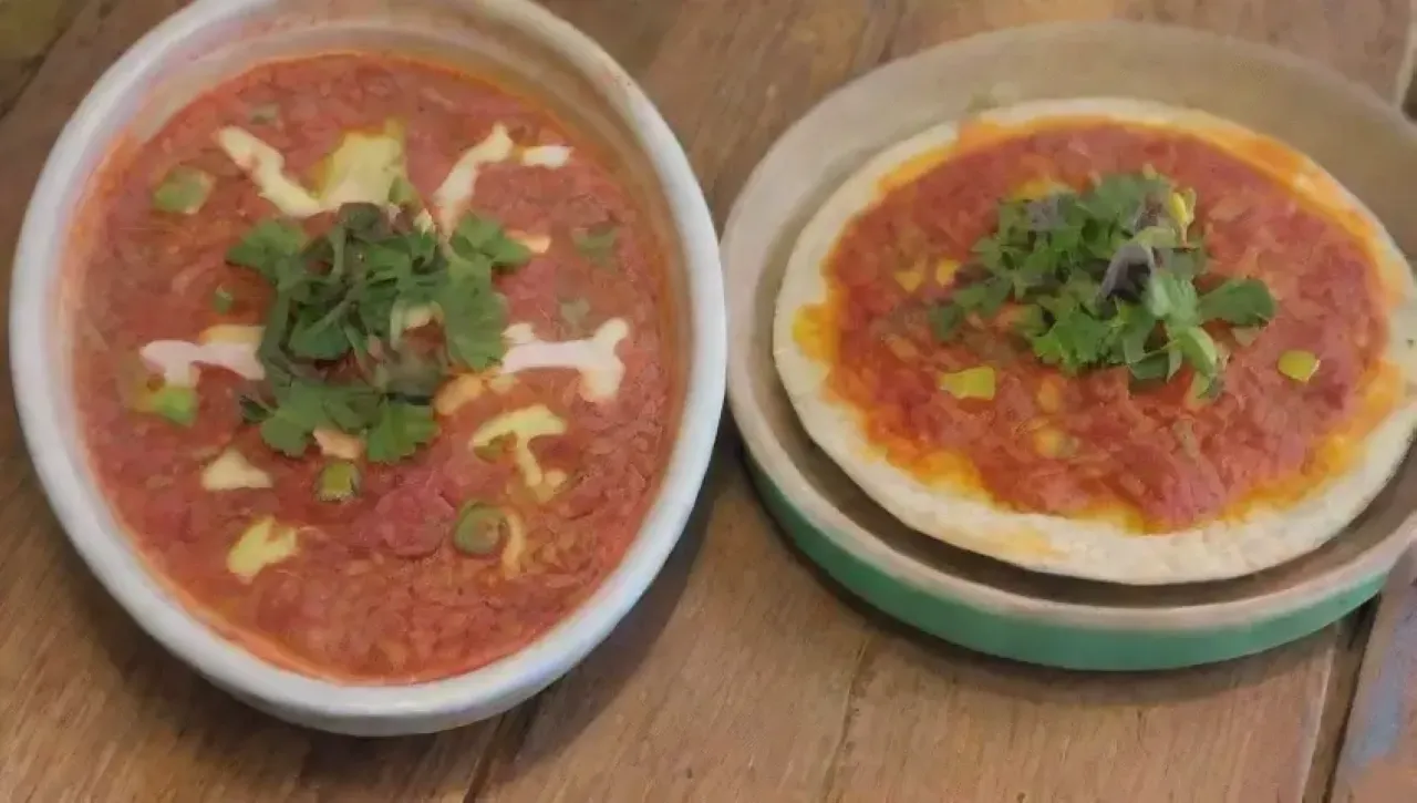 Una mesa rústica llena de tortillas amarillas, salsa roja y risas familiares evoca la calidez de la cultura mexicana
