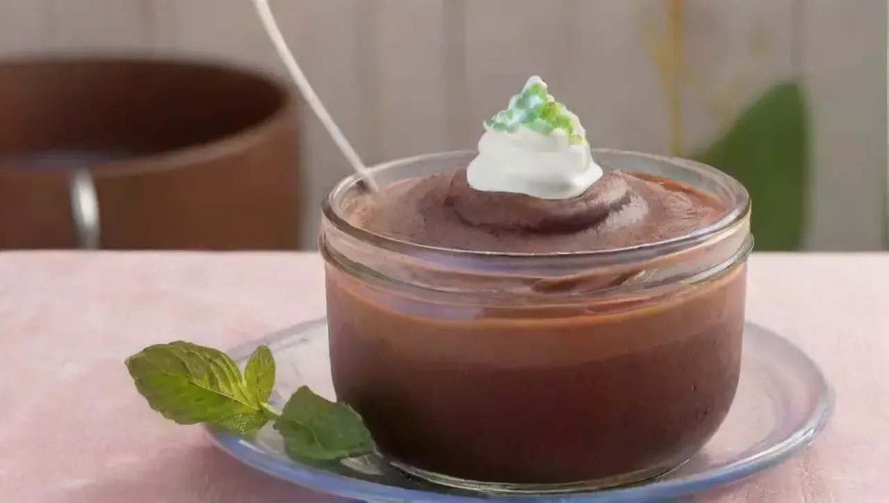 Un acogedor ambiente de cocina con un tazón de pudín de chocolate, frutas vibrantes y luz cálida
