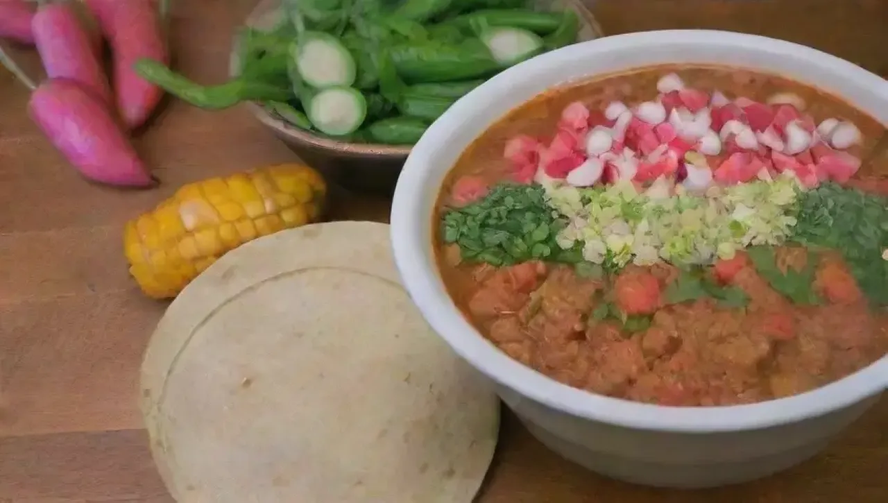 Un festín colorido y aromático de chiles, hominy, cerdo, cilantro, rábanos, lechuga, tortillas, lima, ajo, comino, cebolla, caldo, y especias