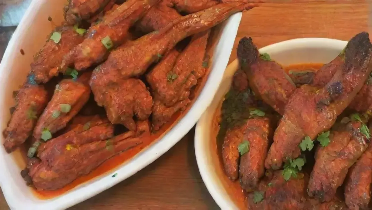 Alitas de pollo BBQ jugosas y crujientes, acompañadas de aderezos y un ambiente festivo