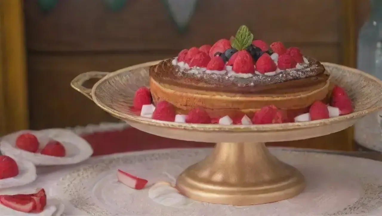 Un lujoso postre decorado con chocolate, crema, frutas y detalles elegantes