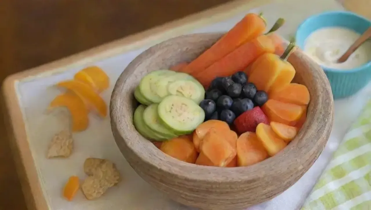 Una colorida y saludable mesa de snacks con frutas, verduras y frutos secos