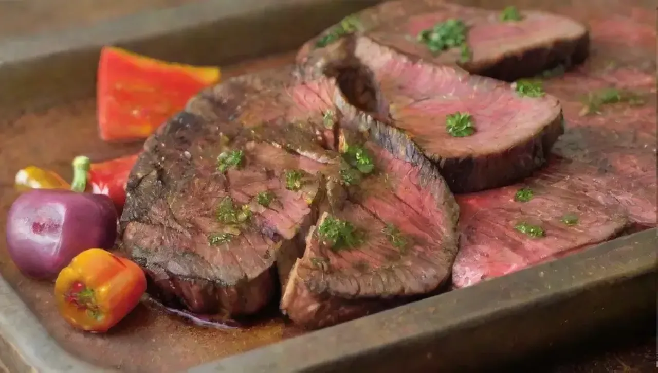 Una deliciosa y acogedora escena de una parrillada con carne jugosa, hierbas frescas y vino tinto