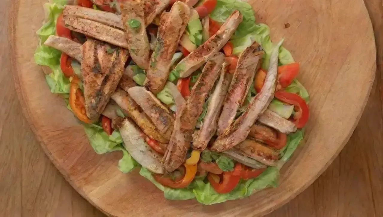 Una ensalada colorida y fresca con pollo, pimientos, aguacate, limón y salsa, todo en una cocina vibrante