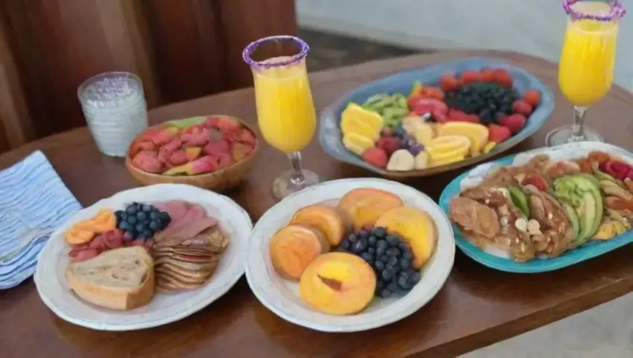 Brunch elegante con cócteles coloridos, frutas frescas y ambiente acogedor