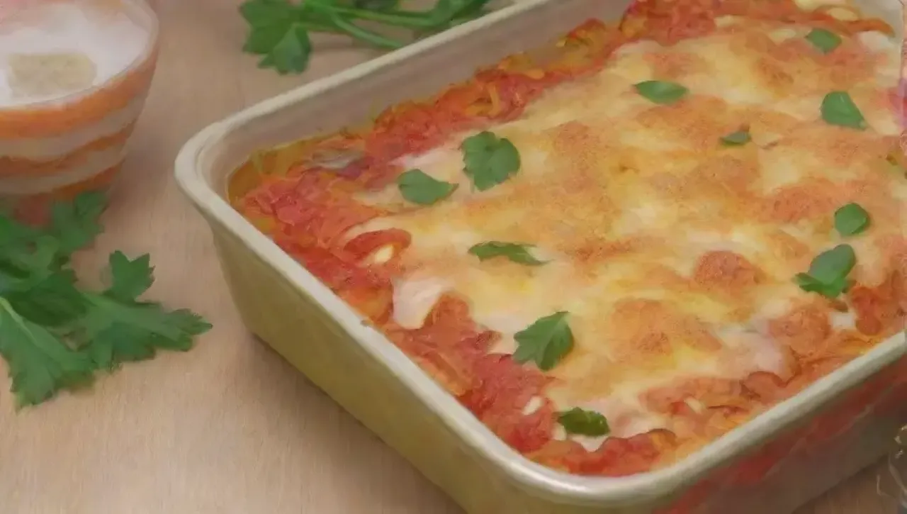 Pasta al horno cremosa con queso burbujeante y hierbas frescas, servida en un ambiente acogedor
