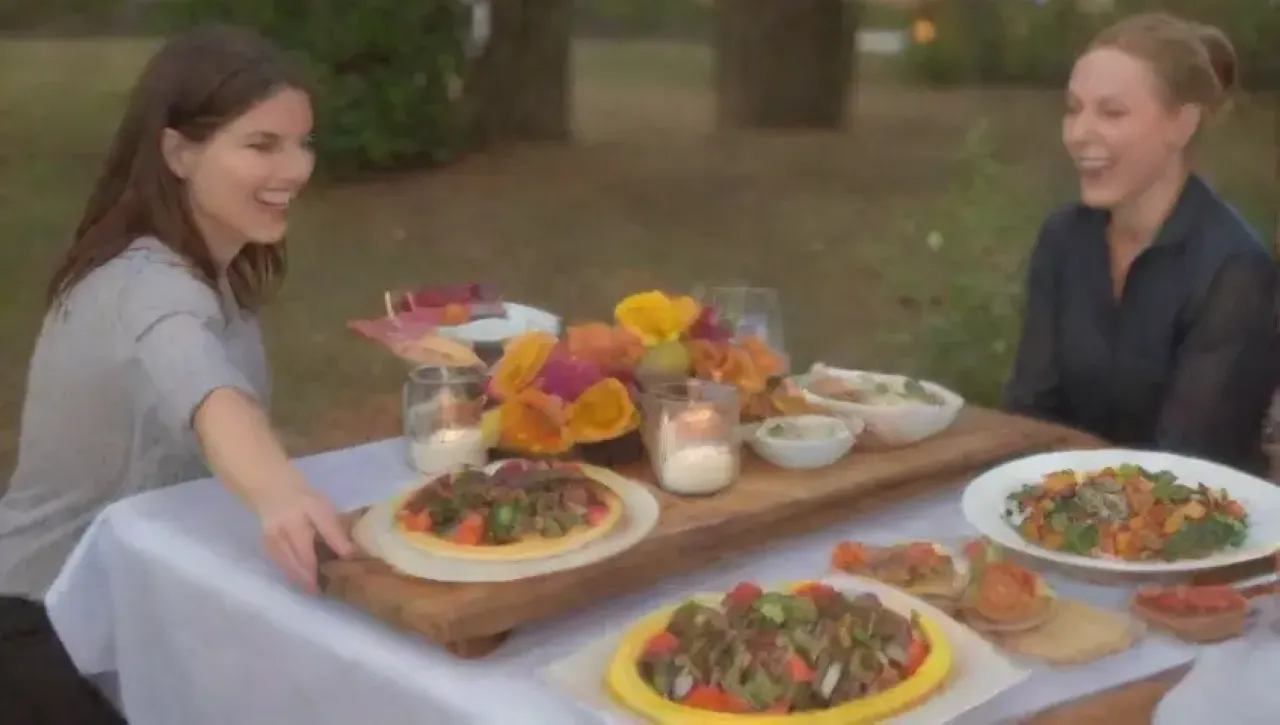 Una mesa vibrante y elegante con comida deliciosa, luces brillantes y un ambiente acogedor