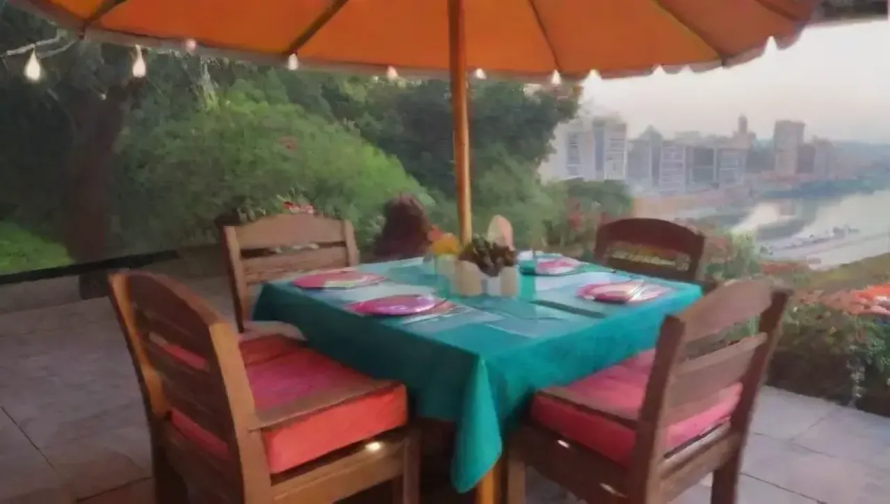 Una terraza vibrante y acogedora, llena de luces, flores, risas y buena comida, ideal para noches memorables