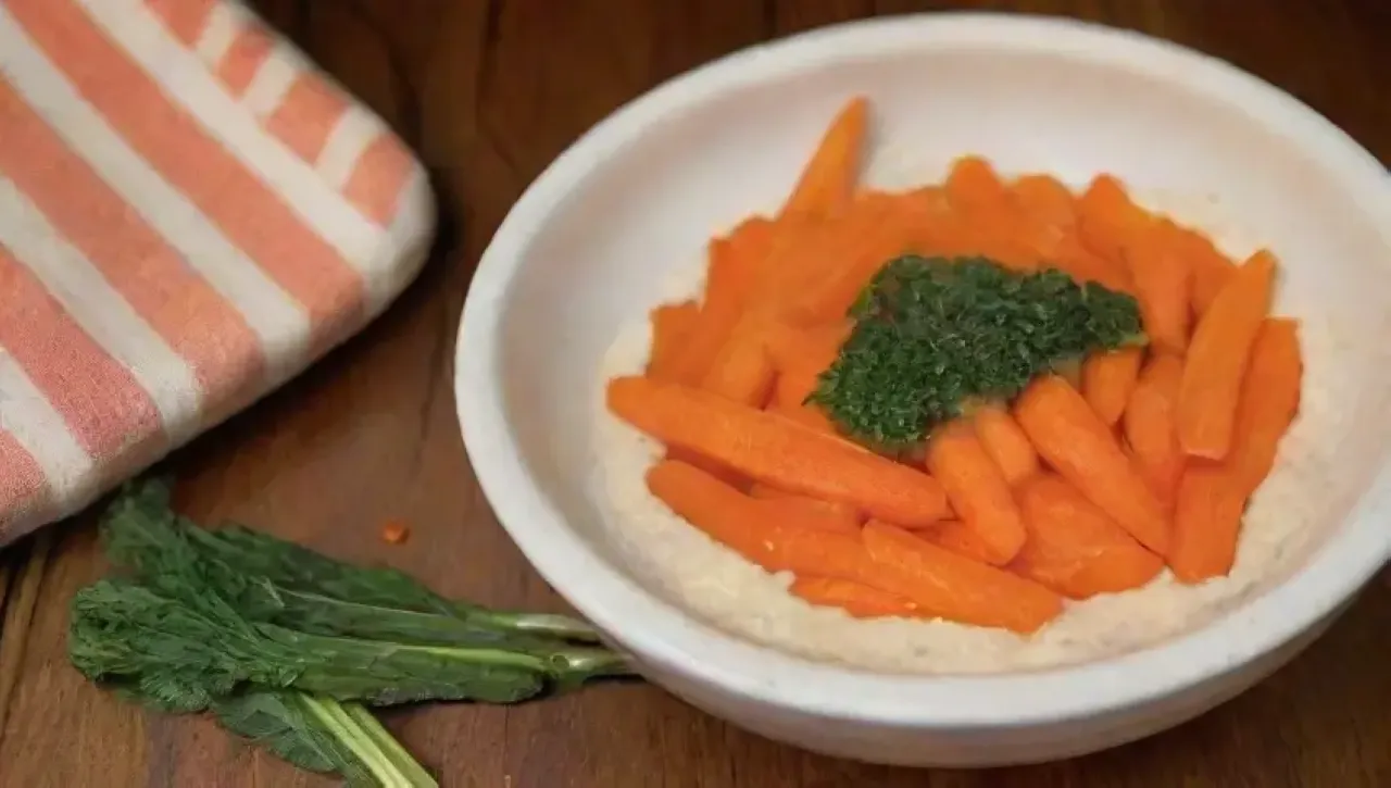 Zanahorias naranjas frescas con hummus y aceite de oliva en un ambiente acogedor