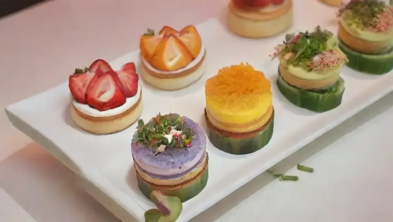 Una elegante mesa con canapés coloridos, delicados y artísticos, rodeada de un ambiente cálido y festivo