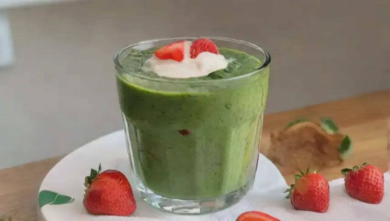 Un batido verde vibrante y saludable se prepara en una cocina alegre