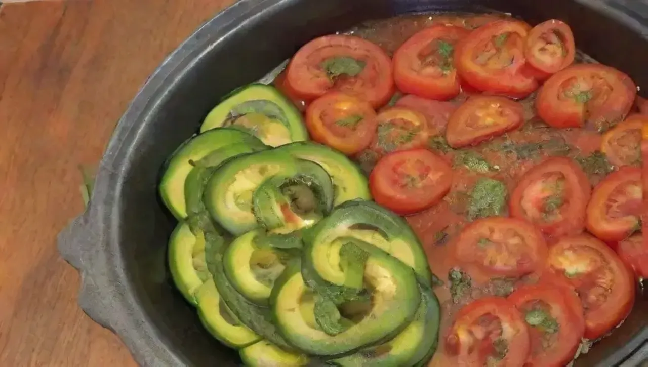 Una familia se reúne en una cocina iluminada por el sol, disfrutando de una colorida y deliciosa comida