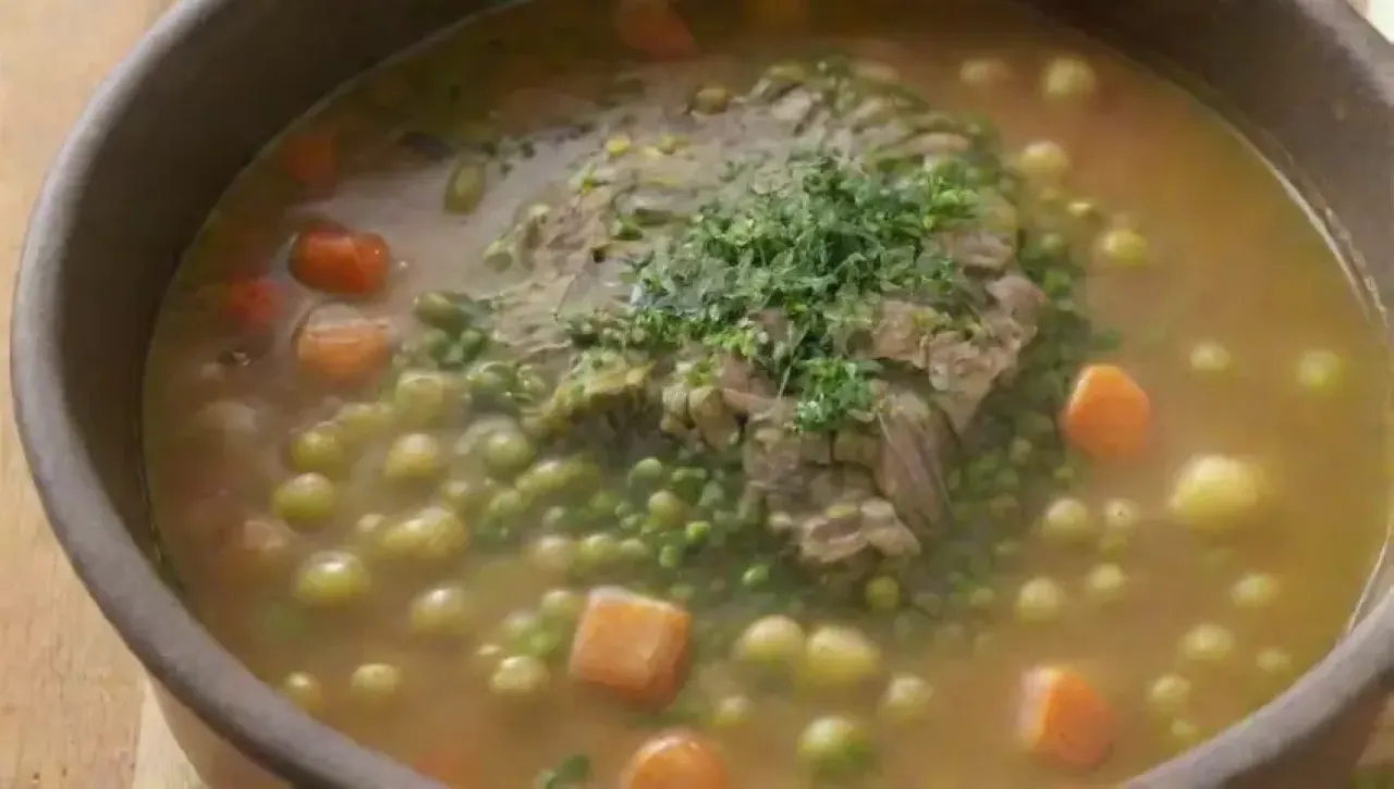 Un guiso de guisantes verdes con hierbas, cebolla, ajo, zanahoria y un toque de crema, en un ambiente acogedor
