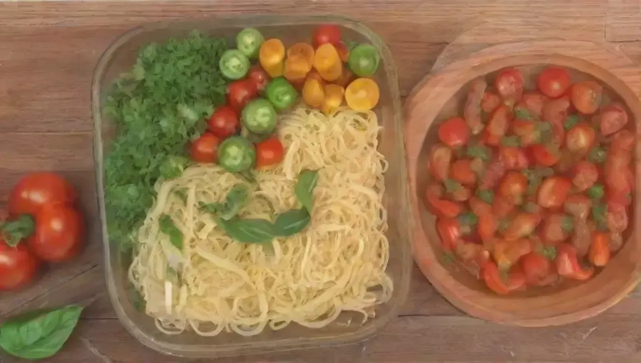 Una mesa acogedora con pasta colorida, tomates frescos y una familia riendo