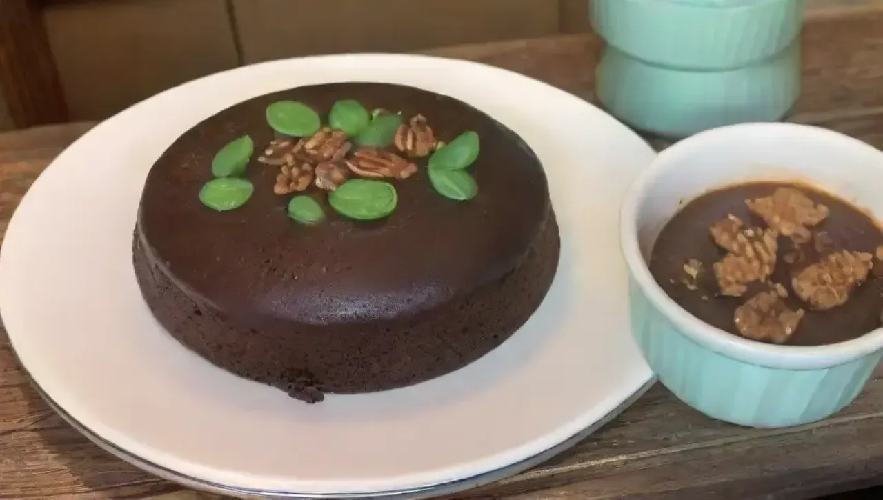 Pastel de chocolate rico y húmedo con espinacas, nueces y frutas, servido en un ambiente acogedor