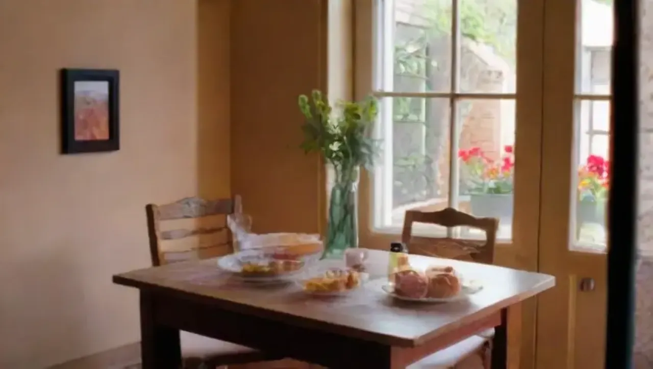 Un rincón acogedor de restaurante con luz suave, velas, plantas, arte colorido y un ambiente cálido y acogedor